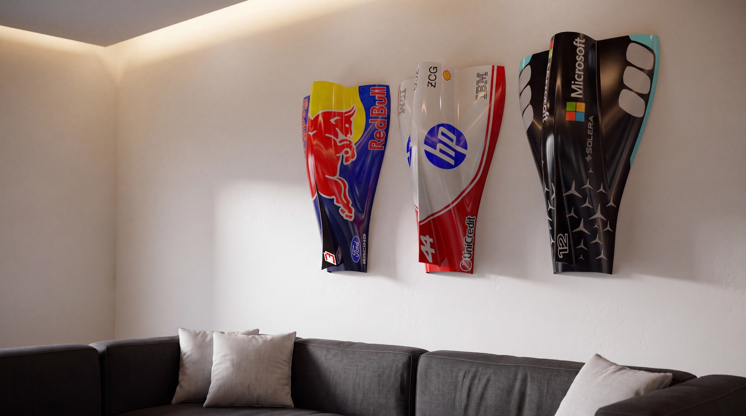 Three Formula 1 inspired engine cover wall pieces mounted above a sofa in a modern living room