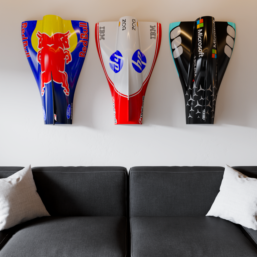 Three engine covers above a grey sofa, Mercedes-inspired black and teal piece at right